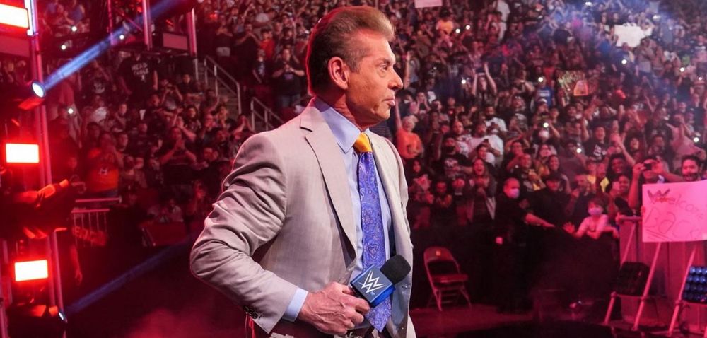 Vince McMahon standing on the stag at a SmackDown show. Behind him are WWE fans (Known as the 'WWE Universe') 